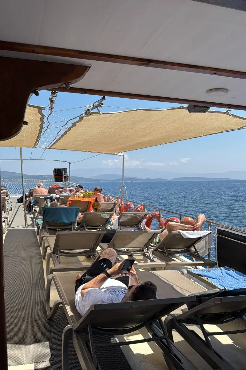 Gölgelikli güvertede dinlenen misafirler